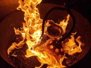 Rakubrand, Flammen mit glühender Keramik und Zange, ch-keramik.ch